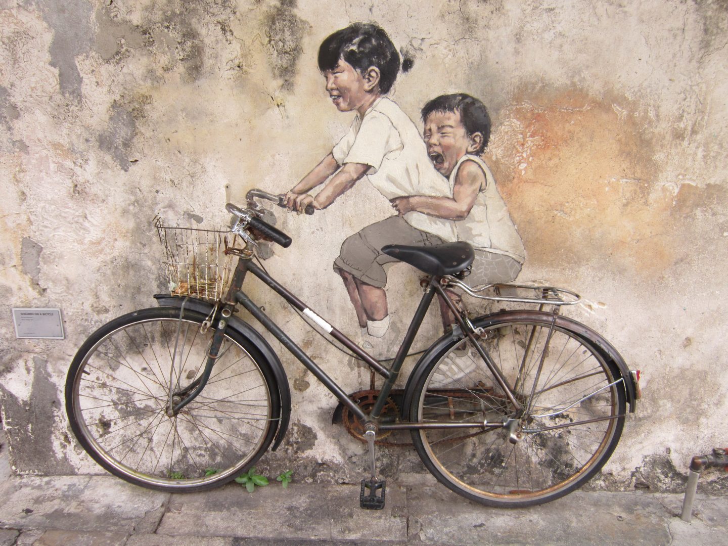 George Town Street Art of 2 children riding a bicycle. 