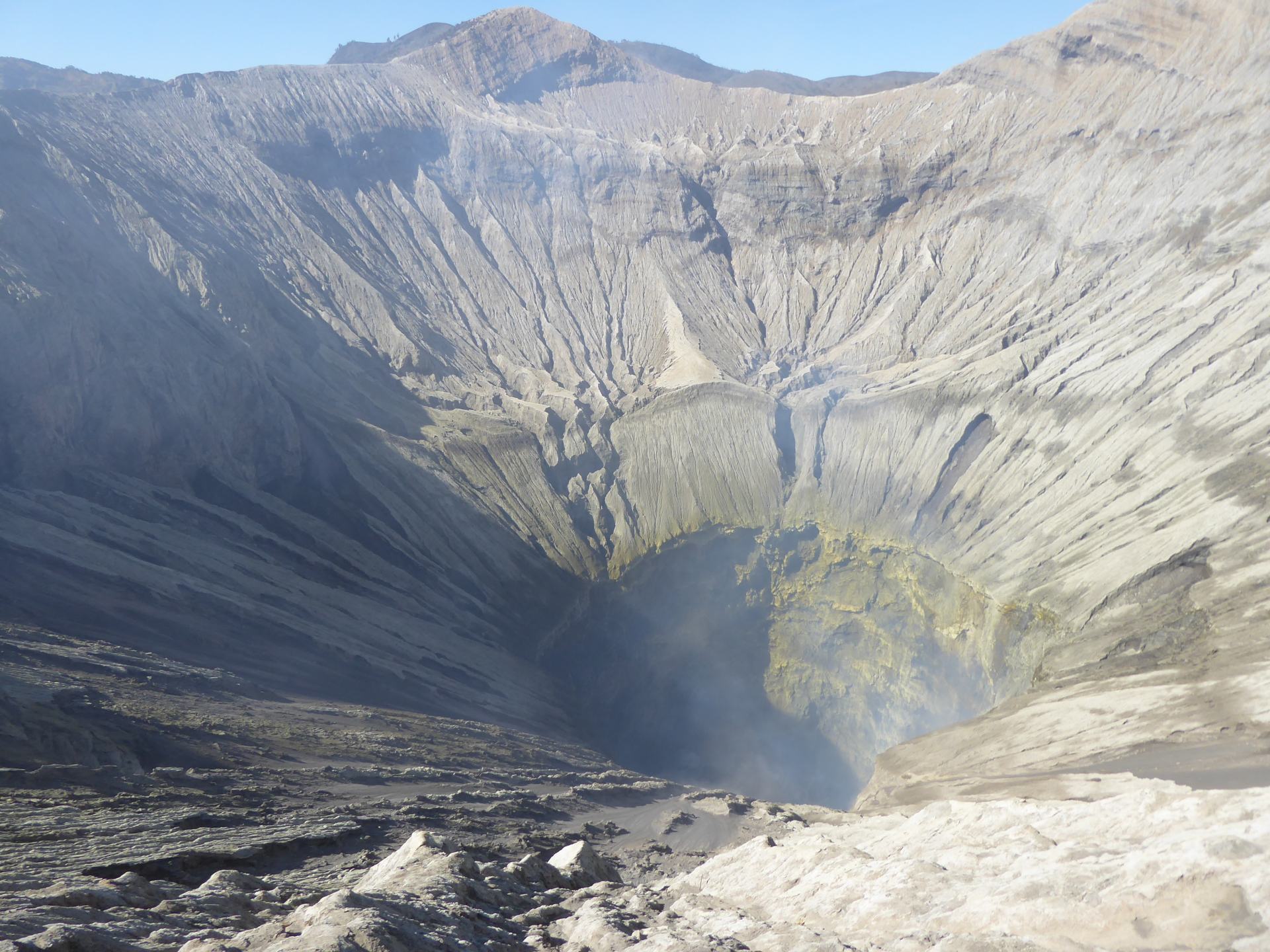 South East Asia Backpacking 6 Month Route - looking into the Crater At Mount Bromo - can see the colour different from the sulphur as it gets deeper - smoke is rising from the crater too. 